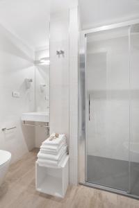 莱圭利亚Residence Dolcemare的带淋浴和盥洗盆的白色浴室