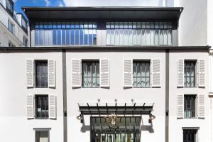 巴黎双长颈鹿酒店的白色的建筑,设有黑窗和阳台