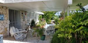 自由港市Bajamar Your Second Home Guest Property的户外庭院设有白色椅子和植物
