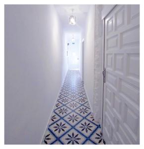 拉拉古纳Casa Lagunera的铺有蓝色和白色瓷砖地板的走廊