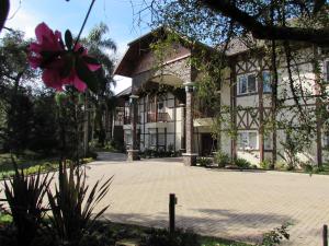 新彼得罗波利斯Hotel Jardins da Colina的前面有粉红色花的房子