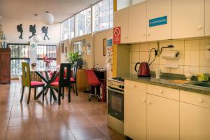 利马Flying Dog Hostel的厨房以及带桌椅的用餐室。