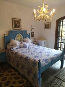 伊泰帕瓦Suites em meio a Mata Atlântica的卧室内的一张蓝色床,配有吊灯