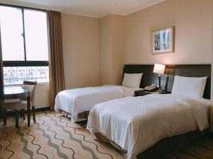 桃园市中悦国际大饭店的酒店客房设有两张床、一张书桌和一个窗户。