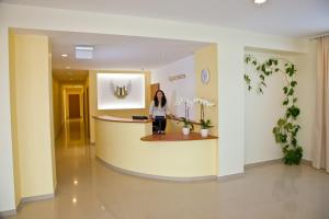乌田纳安赫拉斯酒店的站在医院大厅柜台的女人