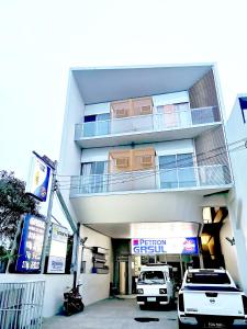 麦克坦GM Rentals SafeStay Apartment at Mactan Airport的两辆车停在大楼前的建筑物