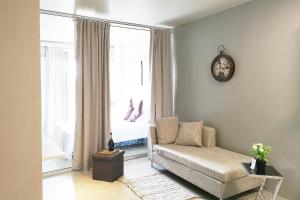 麦克坦GM Rentals SafeStay Apartment at Mactan Airport的客厅配有沙发和墙上的时钟