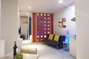 麦克坦GM Rentals SafeStay Apartment at Mactan Airport的带沙发和墙壁的客厅