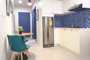 麦克坦GM Rentals SafeStay Apartment at Mactan Airport的厨房配有桌子和冰箱