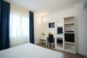 泰塞拉Guest House DOLCE LAGUNA 2的一间卧室配有一张床、一张书桌和一面镜子
