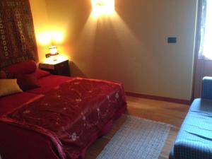 ImerIl Ciliegio的一间卧室配有红色的床和蓝色的沙发