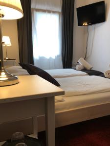 SomeoDonjon B&B e Ristorante的酒店客房设有两张床、一张桌子和一个窗户。
