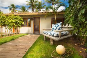 托兰克索Rio Da Barra Villa Hotel的坐在房子前面的草上的一个长凳