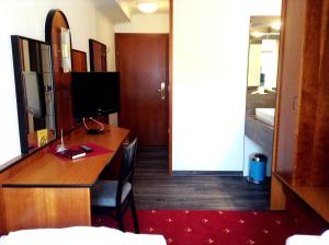 多瑙河畔阿沙赫盖斯特豪弗索尼酒店的一间带书桌和电视的客房以及一间卧室