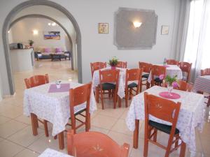 阿吉亚玛丽娜伊斯道拉酒店的用餐室配有桌椅和鲜花