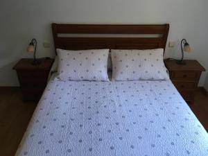 苏加拉穆尔迪Bizentenea的一间卧室配有一张带2个床头柜和2盏灯的床。