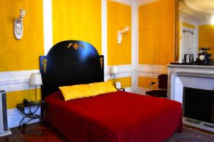 巴黎Hotel Windsor Home的一间卧室配有一张带红色毯子的床和一个壁炉