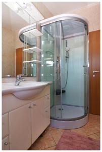 普利莫顿Apartmani Petra的带淋浴和盥洗盆的浴室