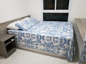 嘎林海斯港Flat Clube Porto Galinhas的一间小卧室,配有蓝色和白色床单