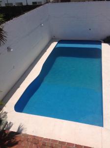 阿卡普尔科Casa Bocoyna的白色墙壁旁边的蓝色游泳池