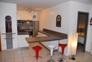 维拉尔-德朗Chalet de Montagne Villard de Lans的厨房配有柜台和2张红色凳子