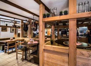 安德马特Berggasthaus Piz Calmot的一间设有木墙和桌子的餐厅和一间酒吧