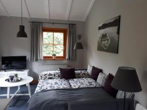 奥尔登堡Blockhausperle im Grunen的一间卧室配有一张床、一张桌子和一个窗户。