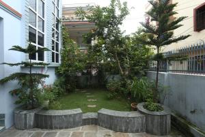加德满都Delights Home的一座种有树木和植物的建筑中的庭院