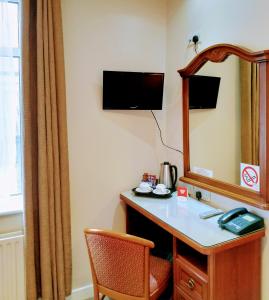 戈尔韦Thirteen On The Green - Eyre Square的客房设有带镜子的梳妆台和椅子。