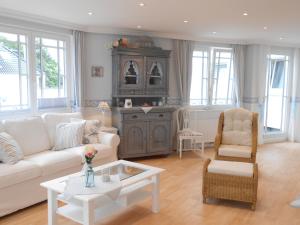 蒂门多弗施特兰德Haus Midsommer的客厅配有白色的沙发和桌子