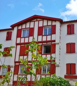 圣让-德吕兹Hôtel La Marisa Grande Plage的红色的白色建筑,设有红色的窗户