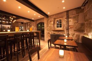 伯尔尼One Suite Hotel - Zollhaus的餐厅内的酒吧配有木桌和椅子