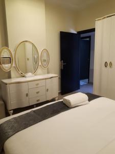 阿吉曼Reef Hotel Aparts (Tabasum Group)的一间卧室配有一张带镜子和水槽的床