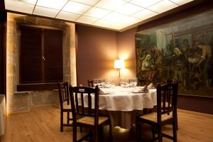 莫雷拉卡德纳尔拉姆酒店的一间设有桌子和墙上绘画的用餐室
