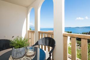 马鲁希奇Appartments Villa Daria的海景阳台上的桌椅