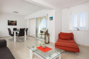 马鲁希奇Appartments Villa Daria的客厅配有红色的沙发和桌子