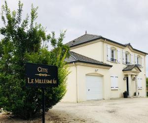 FlavignyGîte "Le Millésime 61"的前面有标志的白色房子