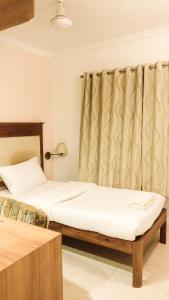 普塔帕蒂Sai Towers的一间卧室配有两张床和窗帘