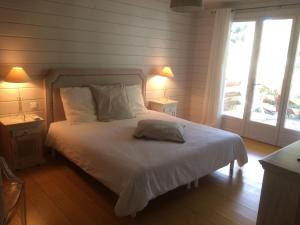 勒·雷约尔·卡纳德尔·苏尔Rayol-Canadel的一间卧室配有一张带白色床单和两盏灯的床。