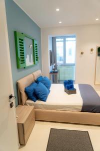 莫尔费塔B&B Mareè Seafront Molfetta的一间卧室配有一张带蓝色枕头的大床