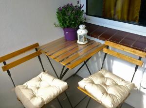 杜伊斯堡Charmant Wohnen的两把椅子和一张木桌,上面有植物