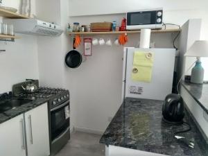 布宜诺斯艾利斯Apartamento cómodo y tranquilo con WiFi en Boedo的小厨房配有炉灶和冰箱
