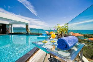 岘港岘港海上凤凰酒店的一个带桌子的游泳池,上面有一条蓝色的毛巾