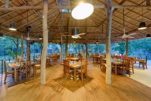 达瓦拉维考塔瓦塔村酒店的一间设有木桌和椅子的餐厅