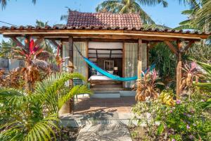 吉利特拉旺安椰子花园度假酒店的花园内带吊床的小房子