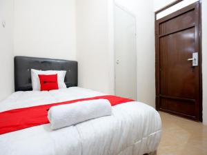 三宝垄RedDoorz near Akademi Kepolisian Semarang的一间卧室配有一张带红色枕头的大床