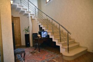 库塔伊西Center Villa Kutaisi的楼梯,房子里,桌子上放有电视