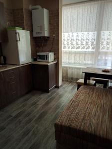 基辅Apartment complex Parklend的厨房配有冰箱、桌子和微波炉