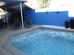 班达伯格魅力之城汽车旅馆的一个带椅子和蓝色墙壁的大型游泳池