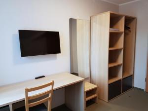 奈达Hotel Jurate的客房设有书桌和墙上的电视